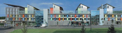 “Sonnenschiff“ der Solarsiedlung Freiburg mit 6500 m² Wohn- und Geschäftsfläche. Hinter den farbigen Elementen befinden sich die Außen- und Fortluftdurchlässe der in die Fassade integrierten Wohnungslüftungsgeräte.