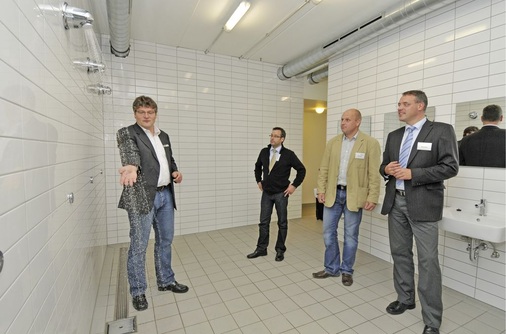 Abb. 2 Solvis-Vertriebsleiter Dipl.-Ing. Karsten Woelk, Viega-Verkaufsberater Gerd Herrmann, Andre Stagge, Techniker des Fachhandwerksunternehmens HLF Heizung-Sanitär und Viega-Planungsberater Marco Trümper (v.l.) im Solvis-Sanitär-Showroom, der zugleich als Duschanlage für die Mitarbeiter dient — und wo so wohl am besten unter Beweis gestellt werden kann, wie praxisgerecht die am Zeichentisch differenziert vorgenommene Auslegung einer Trinkwasseranlage sein kann.