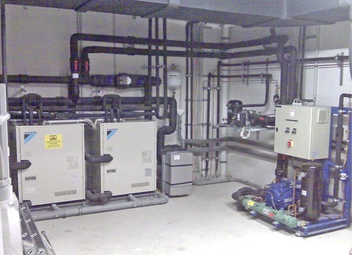 Abb. 6 Blick in die Technikzentrale. Links sind zwei der drei GrundwasserVRV-Einheiten zu sehen, rechts die Ge­werbe­kälte­maschine. - © Daikin
