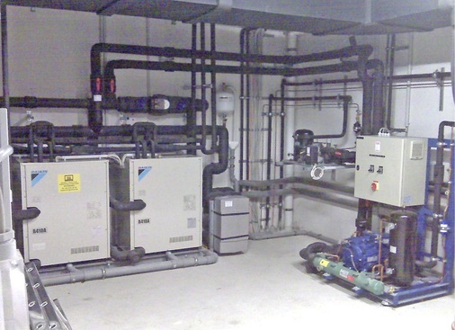 Abb. 6 Blick in die Technikzentrale. Links sind zwei der drei GrundwasserVRV-Einheiten zu sehen, rechts die Ge­werbe­kälte­maschine.