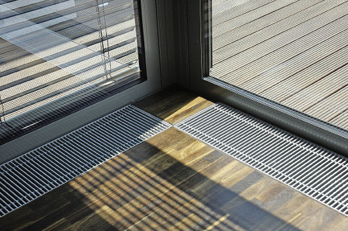 Abb. 6 Induktionskonvektoren im Tagungsraum. Über den Abdeckrost wird die Luft so eingebracht, dass sie an der Fassade ­aufsteigt und dann von der Decke aus die Raumluft durchmischt.