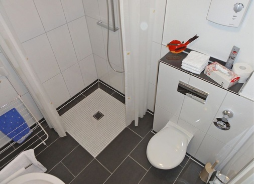 Abb. 4 Barrierefrei und hochwertig im Detail: Die neuen Bäder sind mit einer elektrischen Fußbodentemperierung und einer bodengleichen Dusche ausgestattet. Der elektronische Durchlauf­erhitzer bietet einen guten Temperaturkomfort und sichert die Trinkwassergüte.