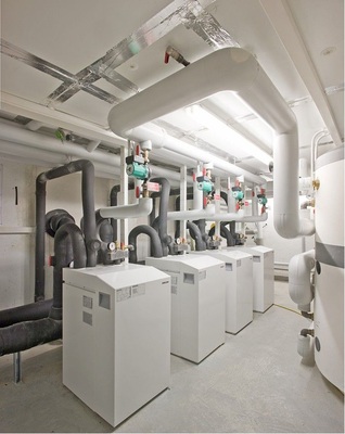 Abb. 3 Kaskadenlösung mit vier Grundwasser-­Wärmepumpen und je 20 kW Heizleistung. Der Planer würde heute eine leistungsgeregelte 80-kW-Wärmepumpe wählen;…