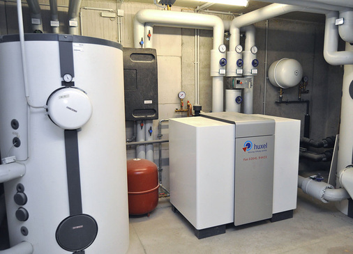 Abb. 2 Die Wärmepumpenanlage im Paulus-Haus mit Sole/Wasser-Wärmepumpe, Pufferspeicher, Trinkwarmwasser-Speicher und Trinkwasser-Ladestation.