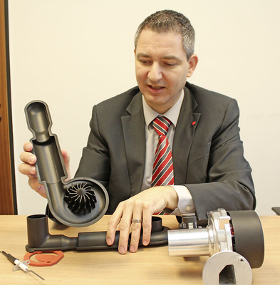 Abb. 3 Burkhard Maier mit einer zerlegten WGB/BBS-EVO-Brennerbaugruppe: „Die Gas-Luft-Durchmischung wird schon im Ansaugschalldämpfer durch mit Strömungssimulationen entwickelte Leitkanäle eingeleitet.“