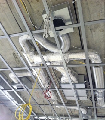Abb. 4 Einbausituation während der Bauphase: ­Zwischendeckengerät, Volumenstromregler, ­Luftauslässe.