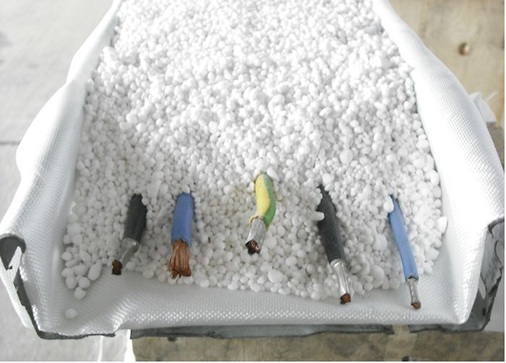 Abb. 4 Hohlglaskugeln als präventiver Brandschutz. Nach der Verfüllung der Kabelpritsche wird das vor der Kabelverlegung eingelegte Brandschutzgewebe noch verschlossen und verschnürt.