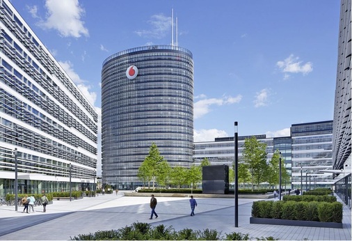 Abb. 2 Die Vodafone-Deutschlandzentrale im Düsseldorfer Stadtteil Heerdt besteht aus einem ellipsenförmigen, 19-geschossigen Hauptgebäude und drei horizontal ausgerichteten Bauteilen, die ähnlich einem Campus um einen gemeinsamen dreieckigen Innenhof gruppiert sind. - © Vodafone GmbH
