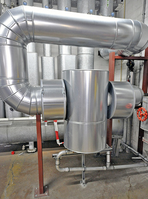 



3
 Einer der drei im Heizungssystem installierten Schlammabscheider SpiroTrap Magnet mit Dämmung. Hier musste aus Platzgründen ein dreifach abgewinkelter „Umweg“ eingebaut werden. Unten sind die Anschlüsse zum Ablassen der Rückstände zu sehen. 
