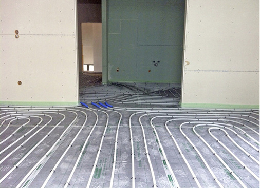 



3
 Verlegte Flächenheizung mit Schutzrohren im Bereich der Bewegungsfuge des Estrichs. 
