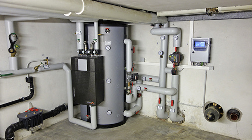 



7
 Unterverteilung der Heizung mit Warmwasser-Pufferspeicher im bereits modernisierten Gebäude Grabenäckerstraße 1, hier noch mit der alten Nahwärmeleitung verbunden. Rechts der vorbereitete Anschluss der neuen Nahwärmeleitung. 
