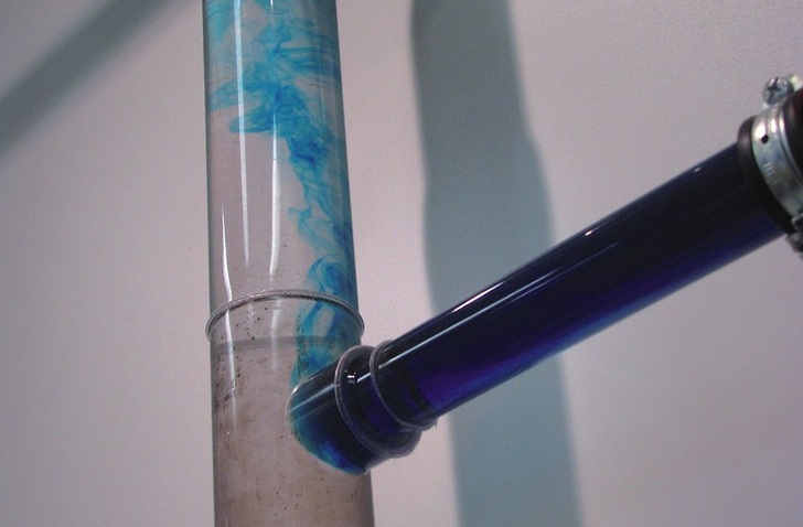 Stagnationsproblem visualisiert: Ausschwemmung von ­eingefärbtem Wasser aus einer Stichleitung in die Steigleitung (Versuchsaufbau im Geberit Informationszentrum Langenfeld). - Geberit