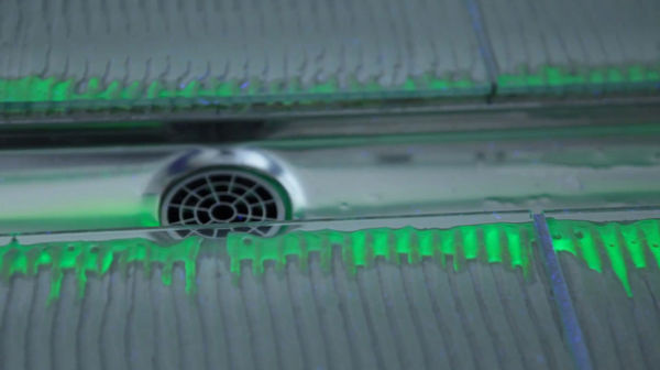 Unter Schwarzlicht wird deutlich, was die Sekundärentwässerung dank Kapillareffekt bewirkt. Feuchtigkeit und Verunreinigungen dringen mehrere Zentimeter weit in das Mörtelbett ein. Bei einem fugenlos geschlossenen Rinnenkörper passiert das nicht. - Tece