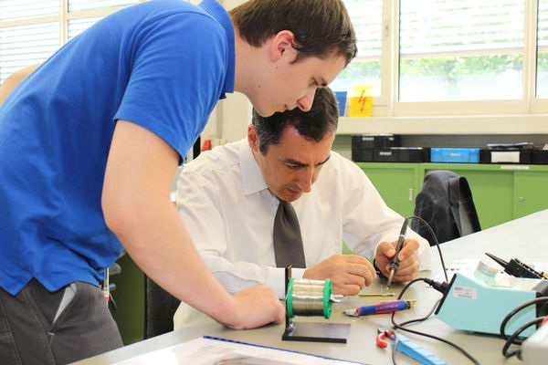 Cem Özdemir lötet in der Lehrwerkstatt seine Taschenlampe. - ebm-papst