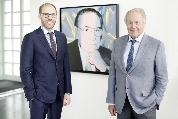 Firmenchef Dipl.-Ing. Siegfried Weishaupt (rechts) und der geschäftsführende Gesellschafter Dipl.-Wi.-Ing. Thomas Weishaupt (links) vor einem Porträt des Firmengründers Max Weishaupt von Andy Warhol. - Max Weishaupt GmbH, Schwendi - © Max Weishaupt GmbH, Schwendi
