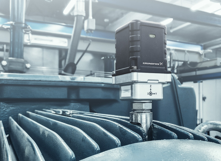 Zwischen den Kühlrippen eines Motors eingeklebter „Grundfos Machine Health“-Sensor. Ein in der Nähe installierter Sender leitet die Daten mehrerer Sensoren über eine Cloud-Anwendung zur Auswertung weiter.
