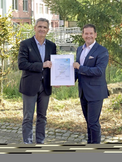 Jan Heckmann, Vorsitzender des BTGA-Fachbereichs Sanitärtechnik überreicht Frank Lissy (rechts), Verkaufsleiter Süddeutschland der ACO Passavant GmbH, die BTGA-Mitgliedsurkunde.