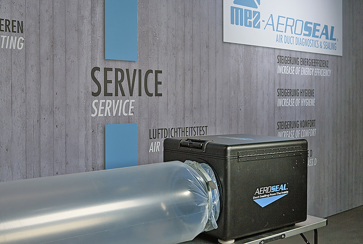 Das vorbereitete Luftleitsystem wird zur Abdichtung mit dem MEZ-Aeroseal-Equipment über einen transparenten Plastikschlauch verbunden. Der in Wasser gelöste MEZ-Aeroseal-Dichtstoff (PVA) wird mithilfe von Druckluft und Wärme zerstäubt und durch die Maschine in die Luftleitung eingeleitet. - © MEZ-Technik
