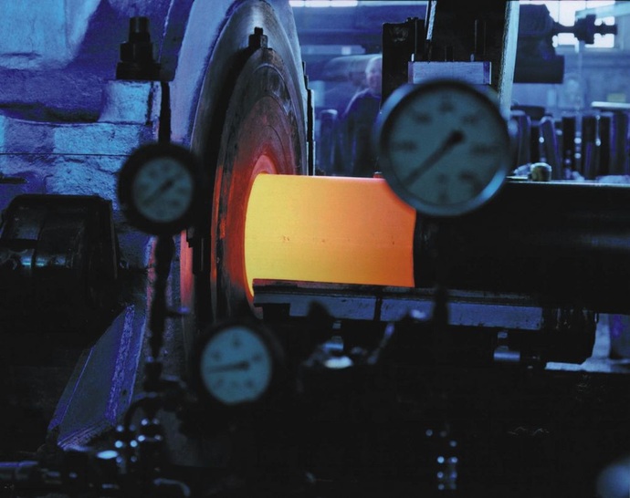 Ein Kupferrohr entsteht. Der glühende Rohling (Billet) wird im ersten Schritt über einem Dorn zum Vorrohr geformt.