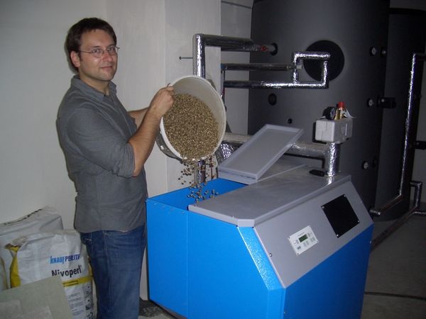 Alexander Findeisen, CEBra-Mitarbeiter beim Befüllen des Kessels mit Biomischpellets