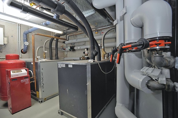 Wärmepumpeninstallation. Ein geschraubter Plattenwärmeübertrager trennt den Grundwasserkreislauf vom internen Wasserkreislauf. Er dient als Wärmequelle für die Wärmepumpe und auch zur direkten Kühlung.