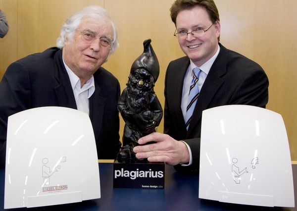 Plagiarius-Initiator Prof. Rido Busse (links) präsentieren zusammen mit dem Leiter des Stiebel-Eltron-Vertriebszentrums Frankfurt, Michel Gamm, Fälschung und Original des Händetrockners HTE und den Plagiarius-Gnom.