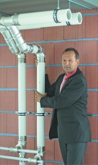 Georg Goldbach mit dem großen Verbundrohrsystem, das für die ­Dimensionen 63 bis 110 mm mit 27 Komponenten alle Anforderungen abdeckt. - © Uponor
