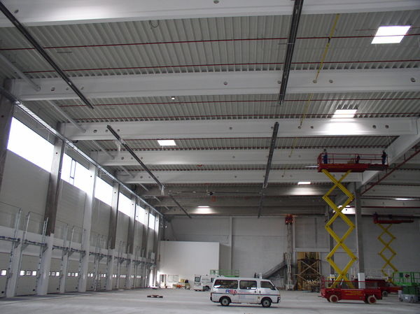 Montage von Dunkelstrahlern in einer Logistikhalle.