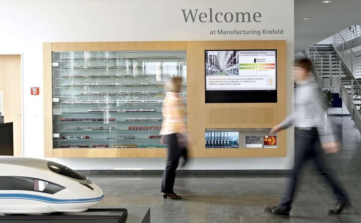 Siemens hat ein neues Energieeffizienzprogramm an über zwanzig Standorten implementiert. Einer davon ist das ICE-Werk in Krefeld. Hier informiert im Eingangsbereich ein Green Building Monitor über die aktuellen Verbrauchsdaten des Werks.