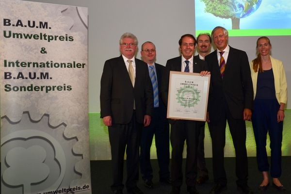 Hermann W. Brennecke präsentiert seine Urkunde zum B.A.U.M.-Umweltpreis 2013, die ihm Prof. Dr. Maximilian Gege (2. von rechts) überreicht hat.
