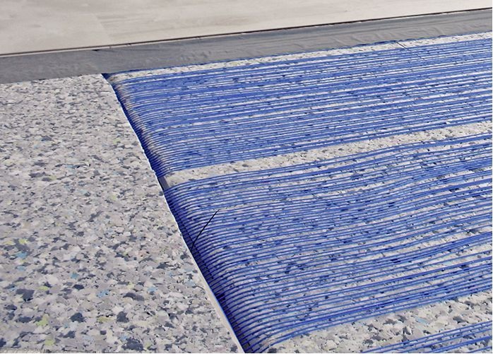 Abb. 1 Die Kapillarrohrmatten der Sportboden­heizung GeoSport liegt direkt in der oberen Schicht des Schwingbodens, zwischen Dämmung und Deckbelag; die Zuleitungen werden in einem Zuleitungskanal untergebracht.