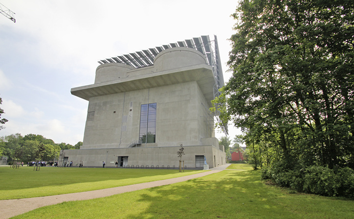 
1
 Der Wilhelmsburger Energiebunker: ehemals ein Flakbunker (45 × 45 m Grundfläche, 47 m Höhe, 80 000 m
3
 Stahlbeton) ist er heute ein Ökokraftwerk mit 2000-m
3
-Kurzzeitpufferspeicher für die umliegenden Gebäude. Die Teilnehmer des SBC Gebäudeautomationsforums 2014 konnten mit dem Speicher, dem Biomethan-BHKW (560 kW
th
), der 560-kW-Solarthermieanlage, den beiden 2,3-MW-Gas-Heizkesseln und der Steuerungstechnik auf Tuchfühlung gehen. 



