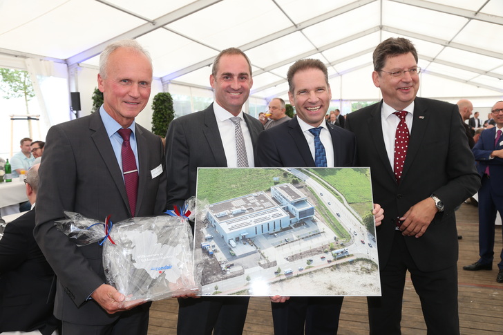 Im Beisein von Wirtschaftsminister Reinhard Meyer (rechts): Willkommensgeschenke zur Eröffnung des neuen Condair-Standorts in Norderstedt von Dr. Bernd Bösche (WTSH) und Marc Mario Bertermann (EGNO) an Condair-CEO Oliver Zimmermann (v.l.).