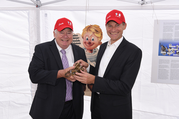 Jørgen M. Clausen, Aufsichtsratsvorsitzender von Danfoss, und Firmen-Präsident Kim Fausing (rechts) mit dem weltweit ersten Heizkörperthermostat von Danfoss aus den Jahr 1943.