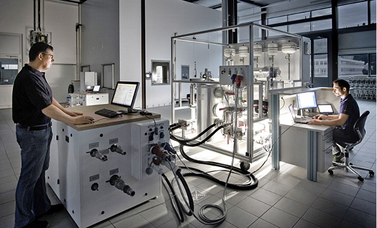 
Weishaupt-Wärmepumpe auf dem Prüfstand im Forschungs- und Entwicklungszentrum, im Hintergrund ist die Klimakammer für Tests von Geräten zur Außenaufstellung zu sehen. 



