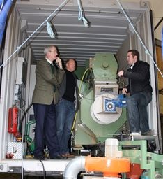 Strohpellet-Fabrik im Container: Sebastian Auth erläutert Prof. Dr. Gerd Manthei und Prof. Dr. Rudolf Griemert (v.r.) die mobile Pelletieranlage. - © FH Gießen-Friedberg
