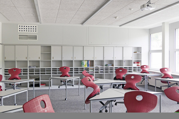 1 Schullüftung quasi ohne Raumverlust: An der hinteren Wand sind von der dezentralen Anlage mit einem FVS-Eco 2 School-600-Gerät lediglich die Luftdurchlässe (links) und die Revisionsklappen (rechts über der Regalwand) zu erkennen und …