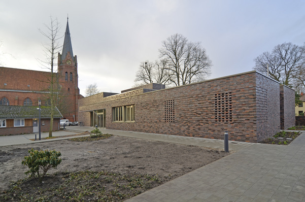 Bild 1 Das neue Gemeindezentrum bietet Platz für einen großen Gemeindesaal und Servicebüros der Gemeinden Sankt Georg, Sankt Lukas und Dietrich Bonhoeffer. Die Klinkerfassade des modernen Gebäudes harmoniert gut mit der Architektur der benachbarten alten Kirche.