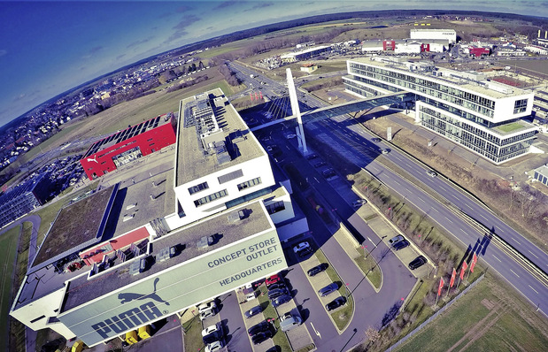 Bild 1: Das neue Verwaltungsgebäude PumaVision II (rechts) erfüllt die gleichen hohen Umweltstandards wie das PumaVision Headquarter (links): Eine Betonkerntemperierung sorgt in Verbindung mit Luft/Wasser-Wärmepumpen für eine energiesparende Beheizung und Kühlung. Eine Regenwassernutzungsanlage stellt den Großteil des Spülwassers für die WC-Anlagen bereit.