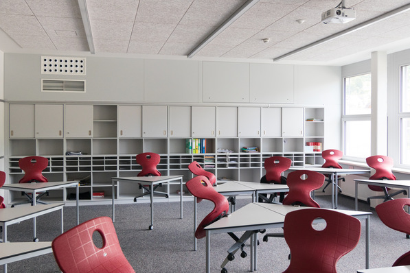 Bild 1 Schullüftung quasi ohne Raumverlust: An der hinteren Wand sind von der dezentralen Anlage mit einem FVS-Eco2School-600-Gerät (LTG) lediglich die Luftdurchlässe (links) und die Revisionsklappen (rechts über der Regalwand) zu erkennen und …