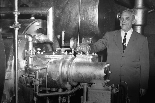 Willis Carrier im Jahr 1950, hier mit der ersten je gebauten Turbokältemaschine, die 27 Jahre lang bei der Onondaga Pottery Company in Syracuse, New York, treue Dienste leistete. Die Carrier Corporation kaufte das Gerät zurück, um es der Smithsonian Institution in Washington, D.C., zur Verfügung zu stellen, wo es heute noch steht.