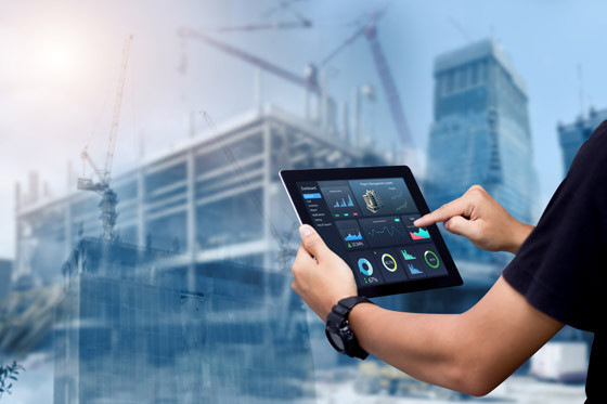 Smart Construction Project management system concept.Hands using digital tablet with Construction Management Software on blurred construction site as background