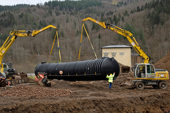 Bild 1 Die Löschwasserbehälter wurden mit zwei Schaufelbaggern an den mitgelieferten Halteschlaufen eingehoben.