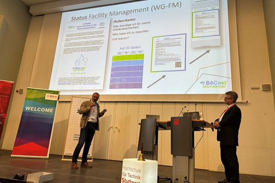 Patrick Lützel (l.) vom TÜV Süd und Rüdiger Schröder (r.) vom Fraport stellen auf der GLT-Anwendertagung 2024 den von der BIG-EU-Arbeitsgruppe Facility Management (WG-FM) entwickelten Leitfaden Cybersicherheit vor.