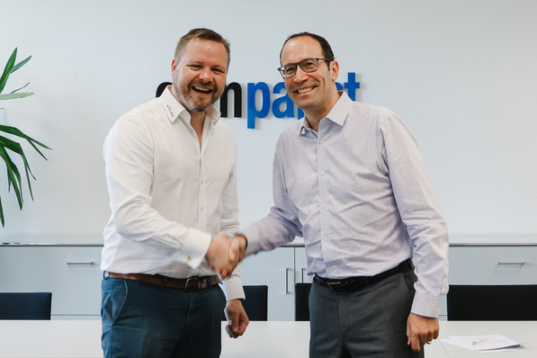 Dr. Hannes Säubert und Tim Hannig besiegeln die Zusammenarbeit mit einem Handshake.