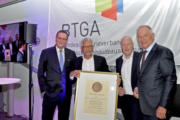 Optimierter, themenrelevanter Alt-Text: Vier Fachvertreter der Gebäudetechnikbranche stehen auf einer Preisverleihung zusammen; Einer überreichte eine gerahmte Auszeichnung für innovative Lösungen im Bereich smartes Energiemanagement vor einem BTGA-Banner. - © ja / BTGA