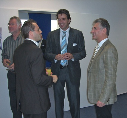 Xavier Feys (rechts), Managing Director von Daikin Airconditioning Germany, und Arno Schmitt (Mitte), Regionalleiter des Vertriebsbüros Frankfurt, im Gespräch mit einem von 120 Gästen der Eröffnungsfeier der neuen Büro- und Schulungsräume.