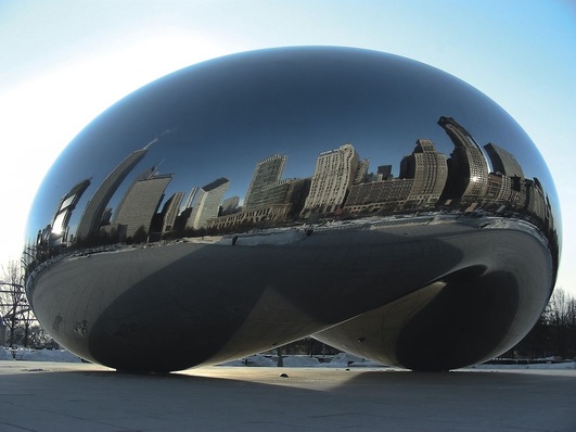 Hochhäuser aus zwei Jahrhunderten spiegeln sich im Cloud Gate (Wolkentor) des indisch-englischen Bildhauers Anish Kapoor, Chicagos meist fotografierter Sehenswürdigkeit. Die Skulptur aus hochglanzpoliertem Edelstahl in Form einer Bohne — von den Bürgern der Stadt deshalb “The Bean“ genannt — ist 10 m hoch, 20 m lang, 13 m breit und rund 100 t schwer.