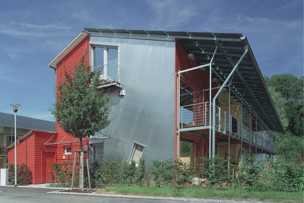Plusenergiehaus1)-Architektur in der Solarsiedlung Freiburg. Das überstehende Photovoltaikdach schirmt im Sommer die Südfassade ab, lässt aber in der Heizperiode die Sonne ins Gebäude.