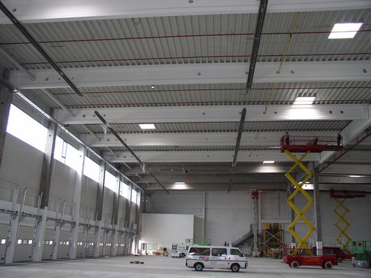 © Vacurant
 Montage von Dunkelstrahlern in einer Logistikhalle.